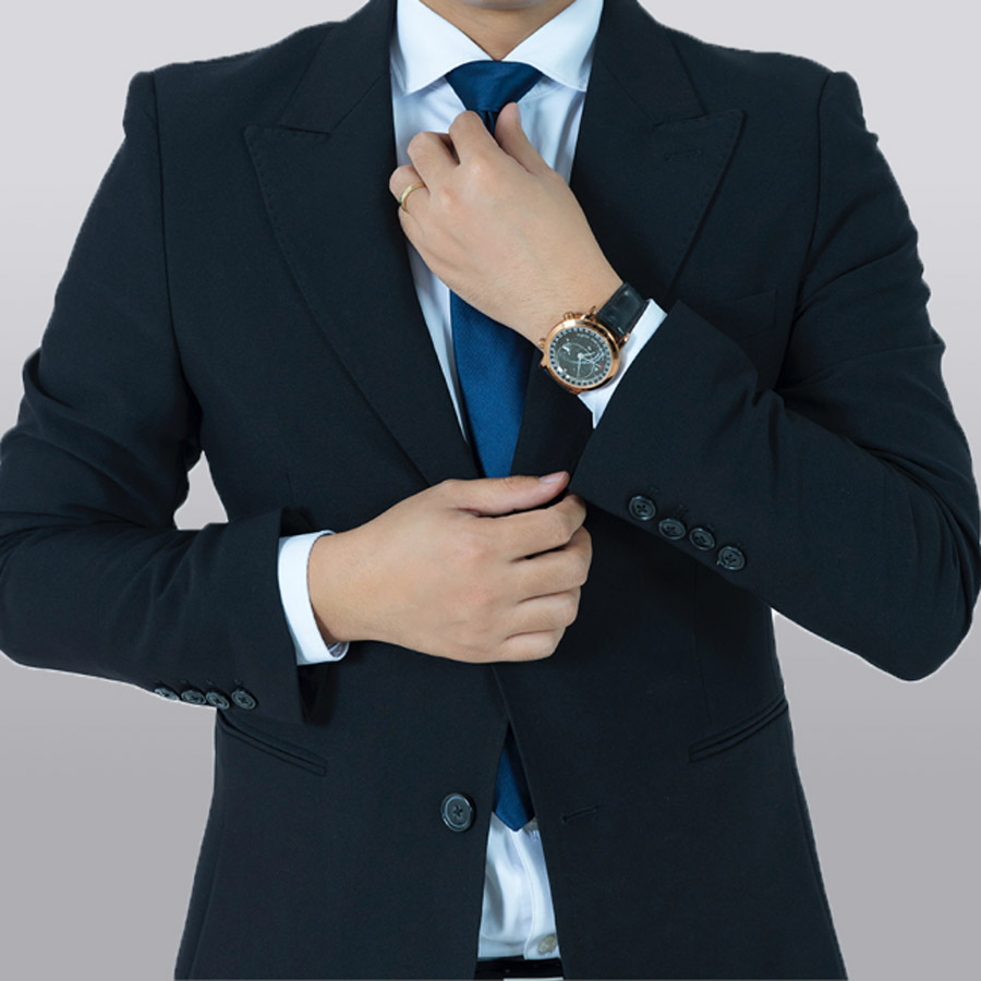 Hombre ajustándose la corbata azul de un traje